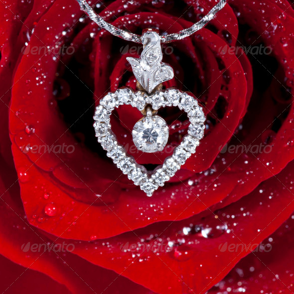 Diamond Heart Shape Pendant With Red Rose Background Stock Photo