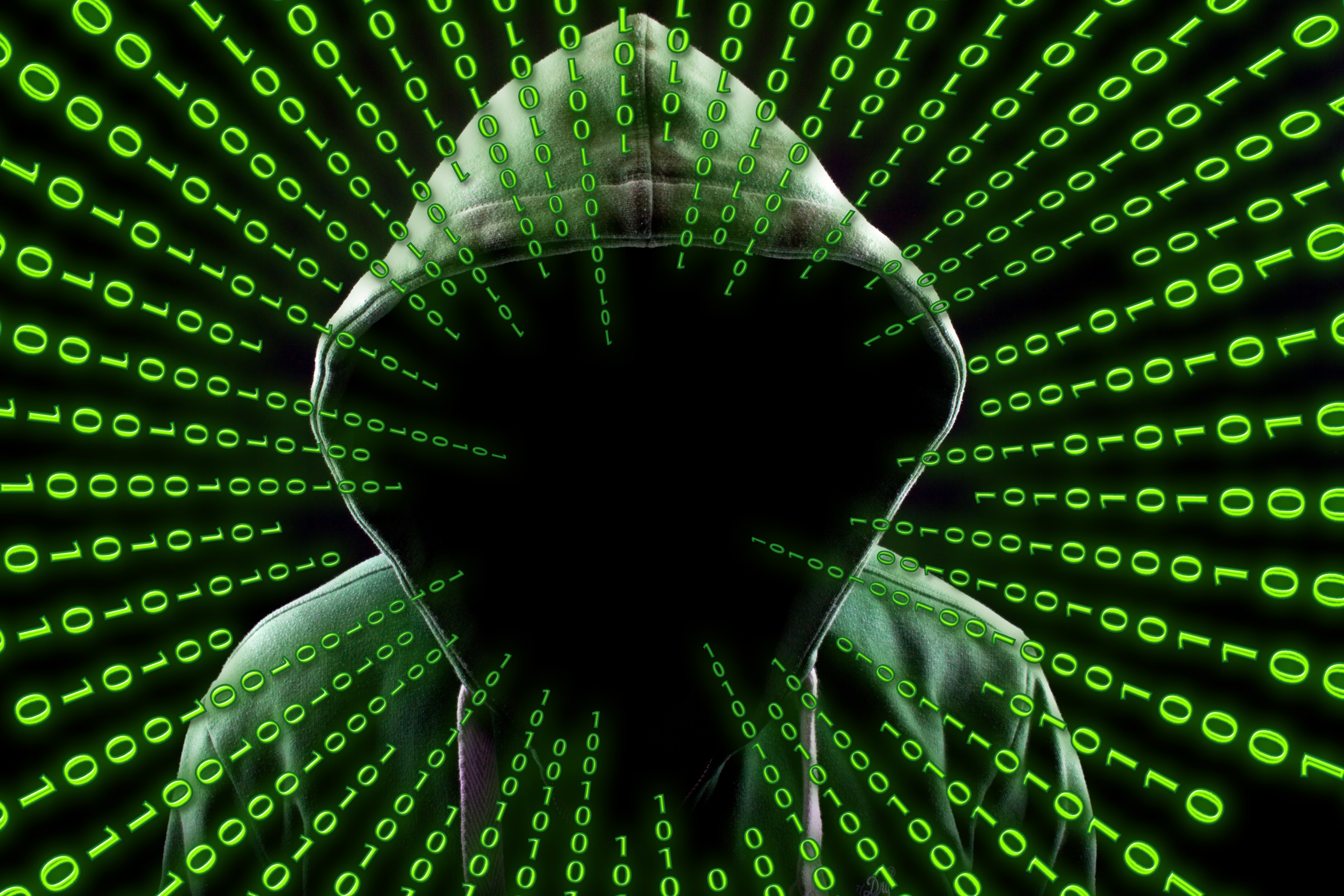 A hooded figure silhouetted against a backdrop of cascading binary code, symbolizing the mysterious world of hacking and cybersecurity