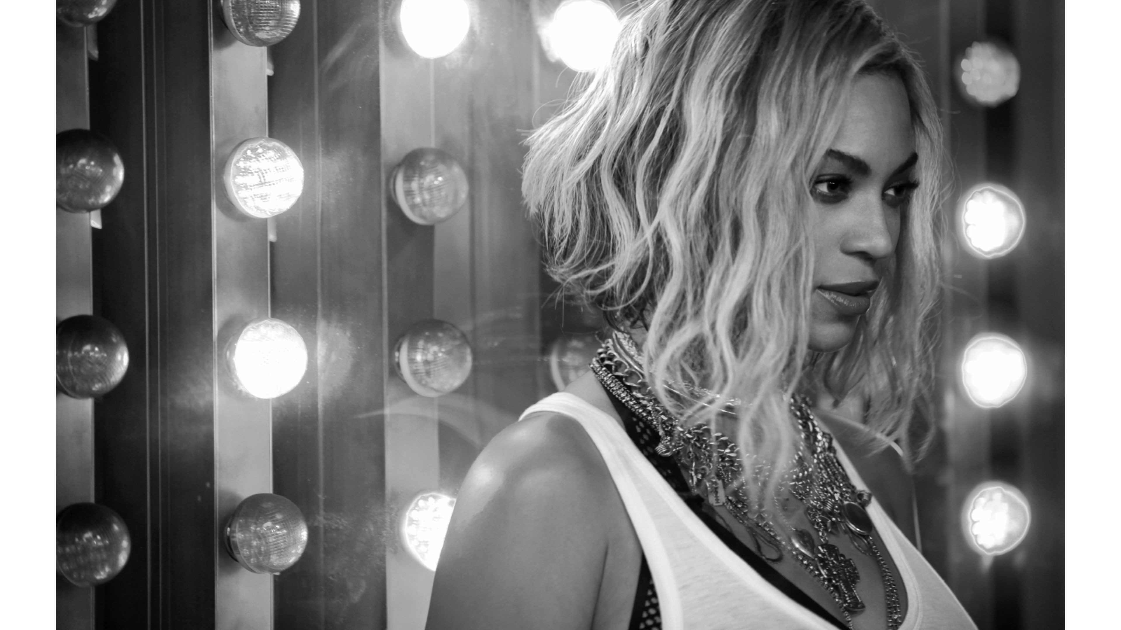 Black and white photo of Beyoncé in front of a vanity mirror with lights