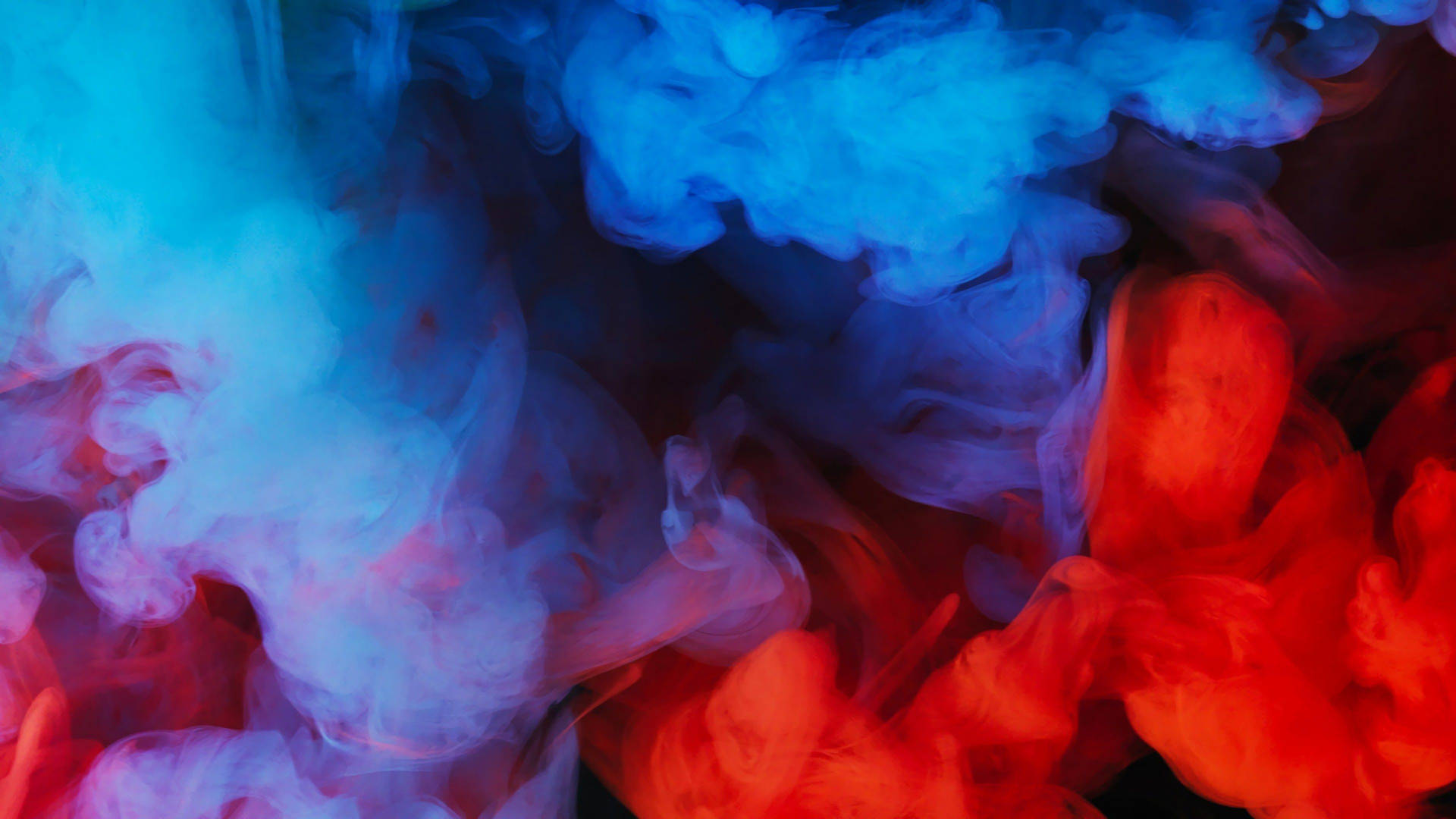 Abstract swirls of vibrant red and blue smoke creating a dynamic and ethereal background