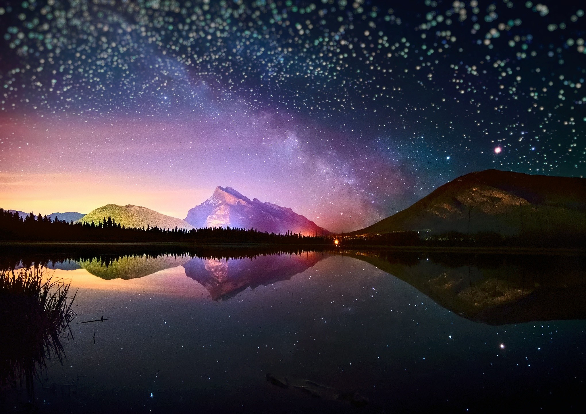 Stunning 4K night sky wallpaper featuring a breathtaking reflection of the Milky Way and mountains on a calm lake