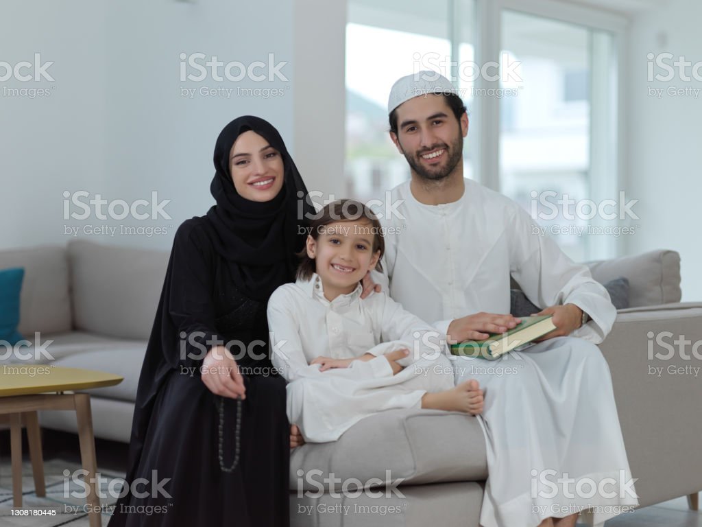 Young Muslim Family Reading Quran During Ramadan Stock Photo