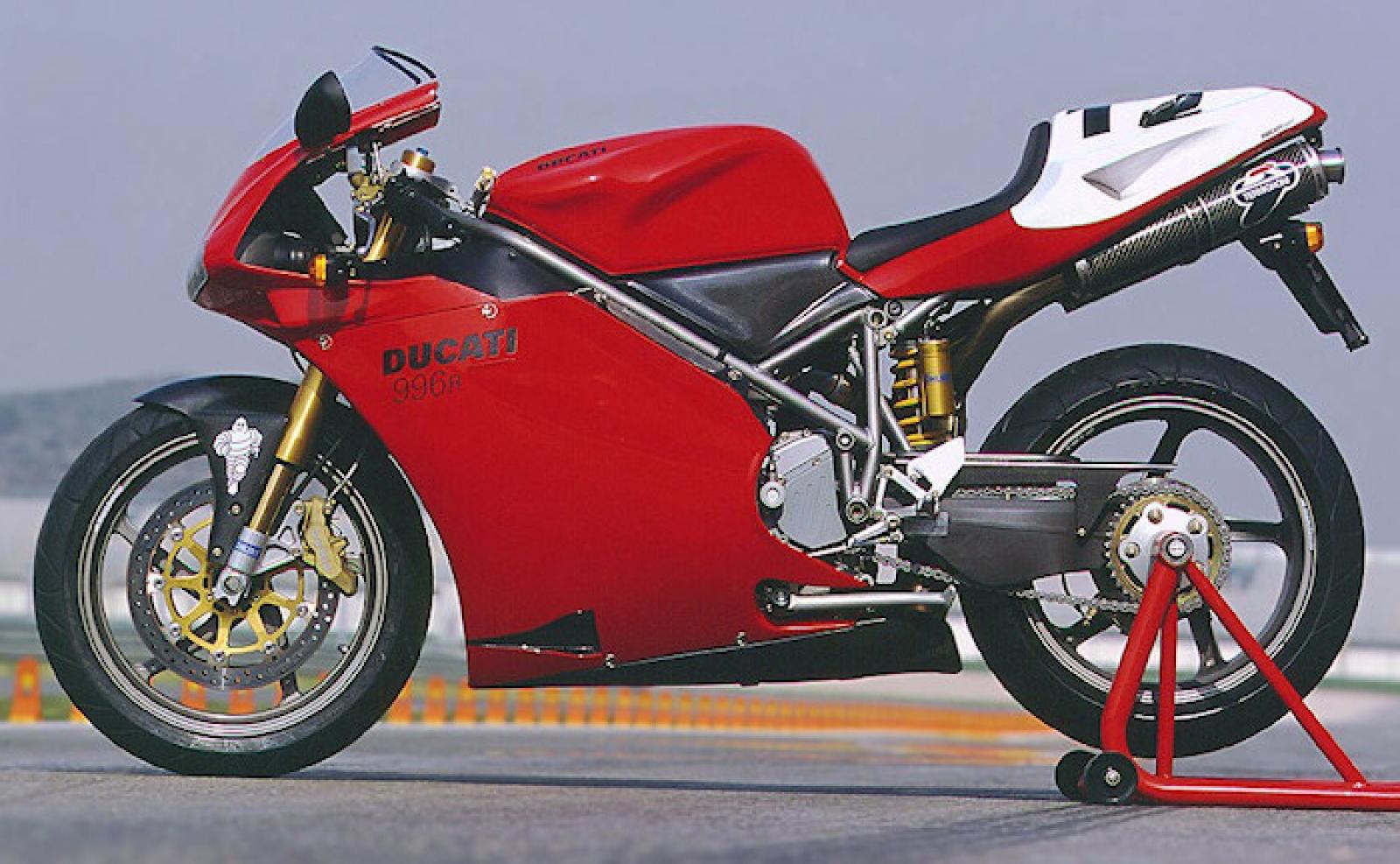 A Ducati 996 motorcycle on a race track, showcasing its iconic red and white racing livery and powerful design