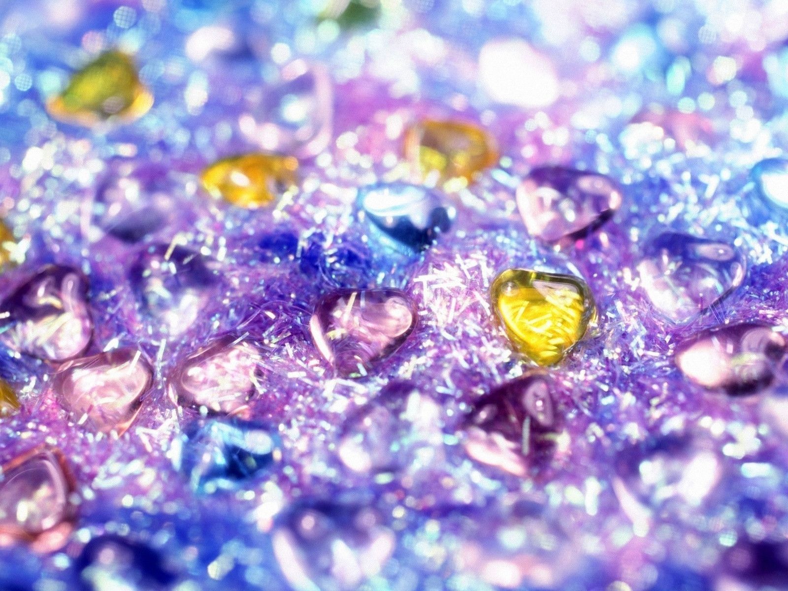 Close-up of iridescent pink glitter with heart-shaped beads, creating a sparkly and textured background