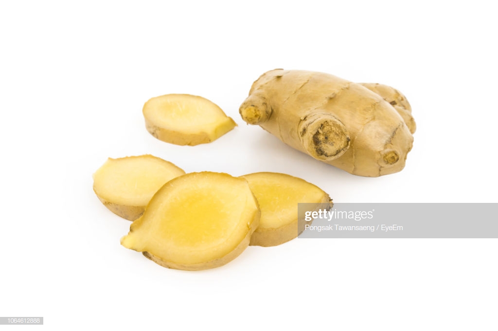 Closeup Of Chopped Ginger Against White Background Stock Photo