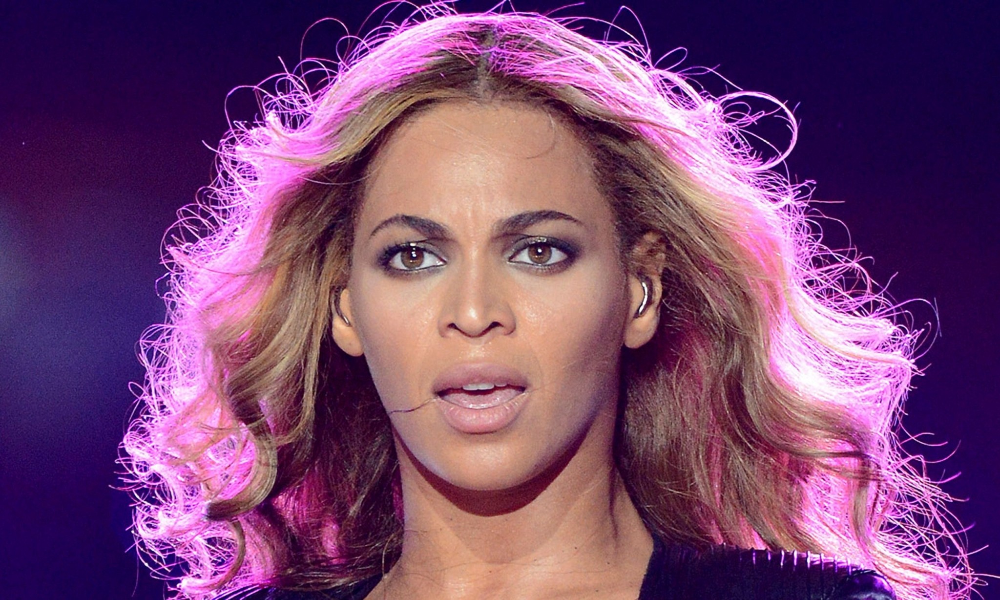 Beyoncé performing on stage with vibrant pink-highlighted hair