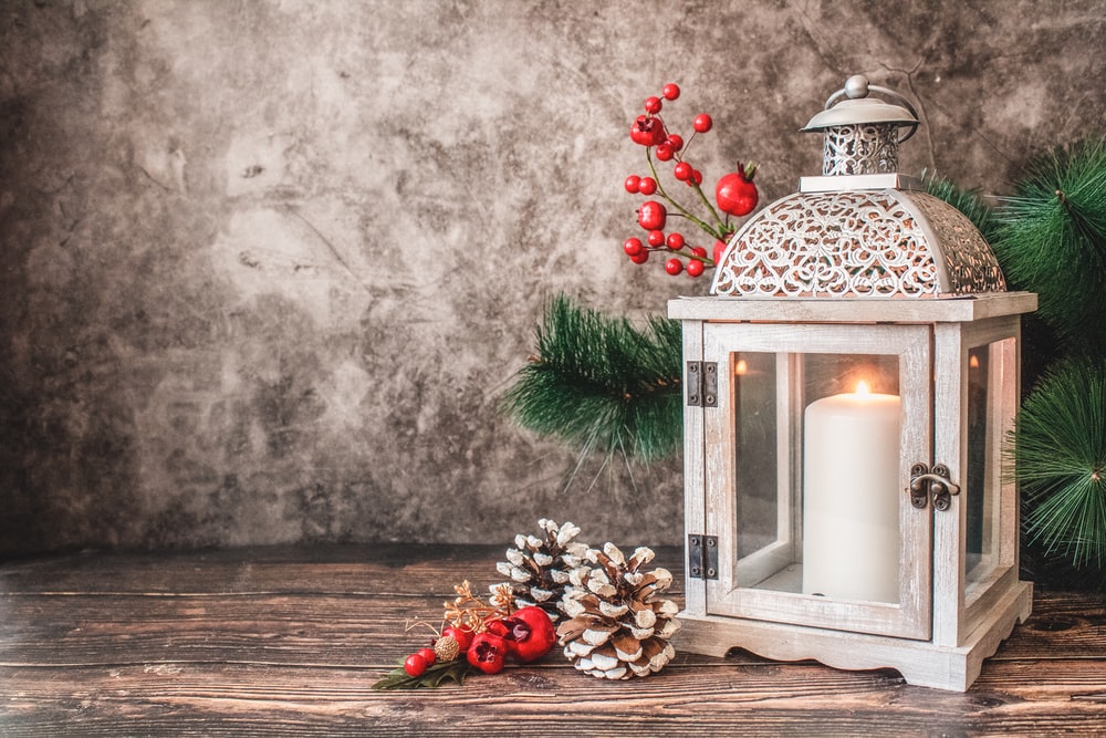 White Pillar Candle In Lantern Beside Wall Photo Image On