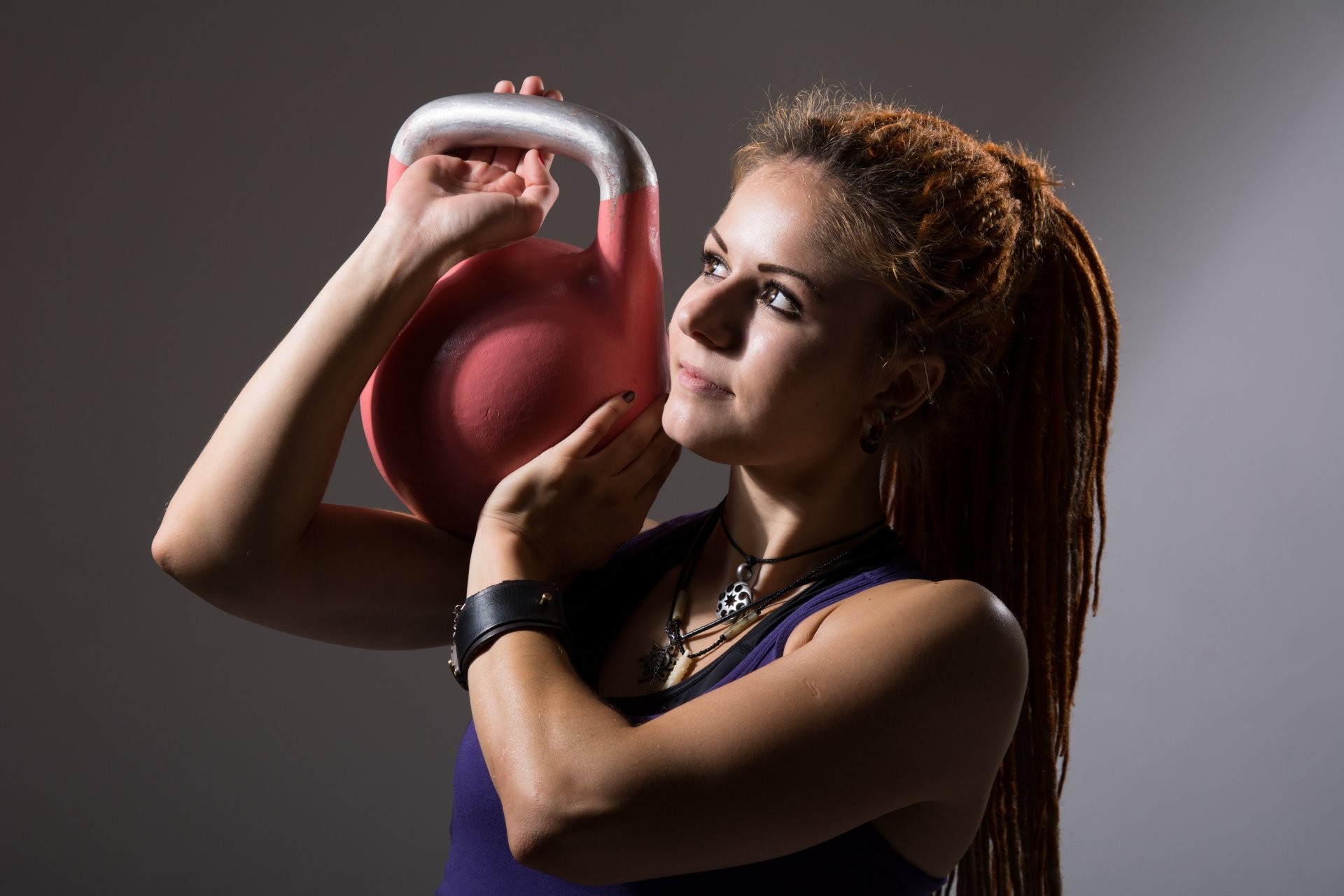 Woman performing a kettlebell exercise, showcasing strength and fitness