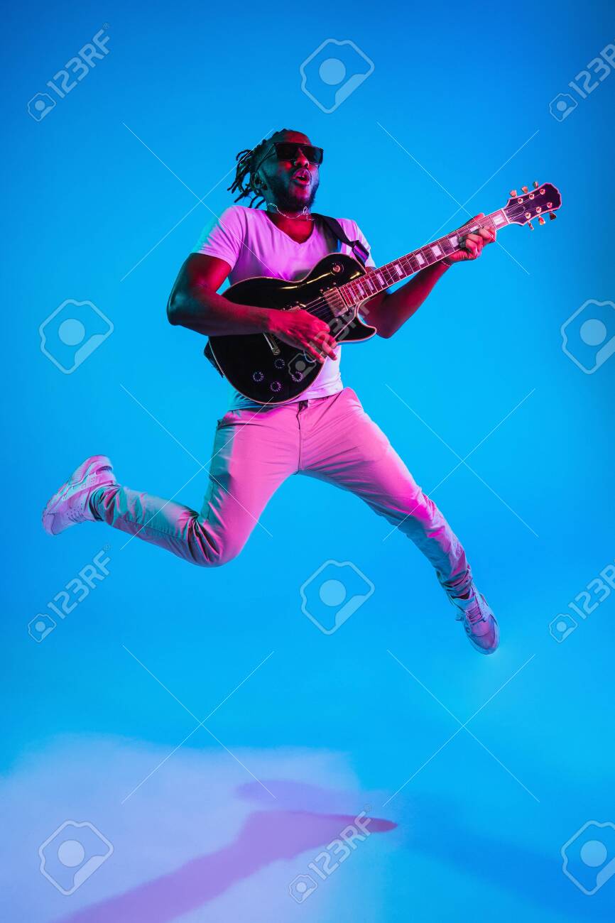 Young African American Musician Playing The Guitar In Jump Like