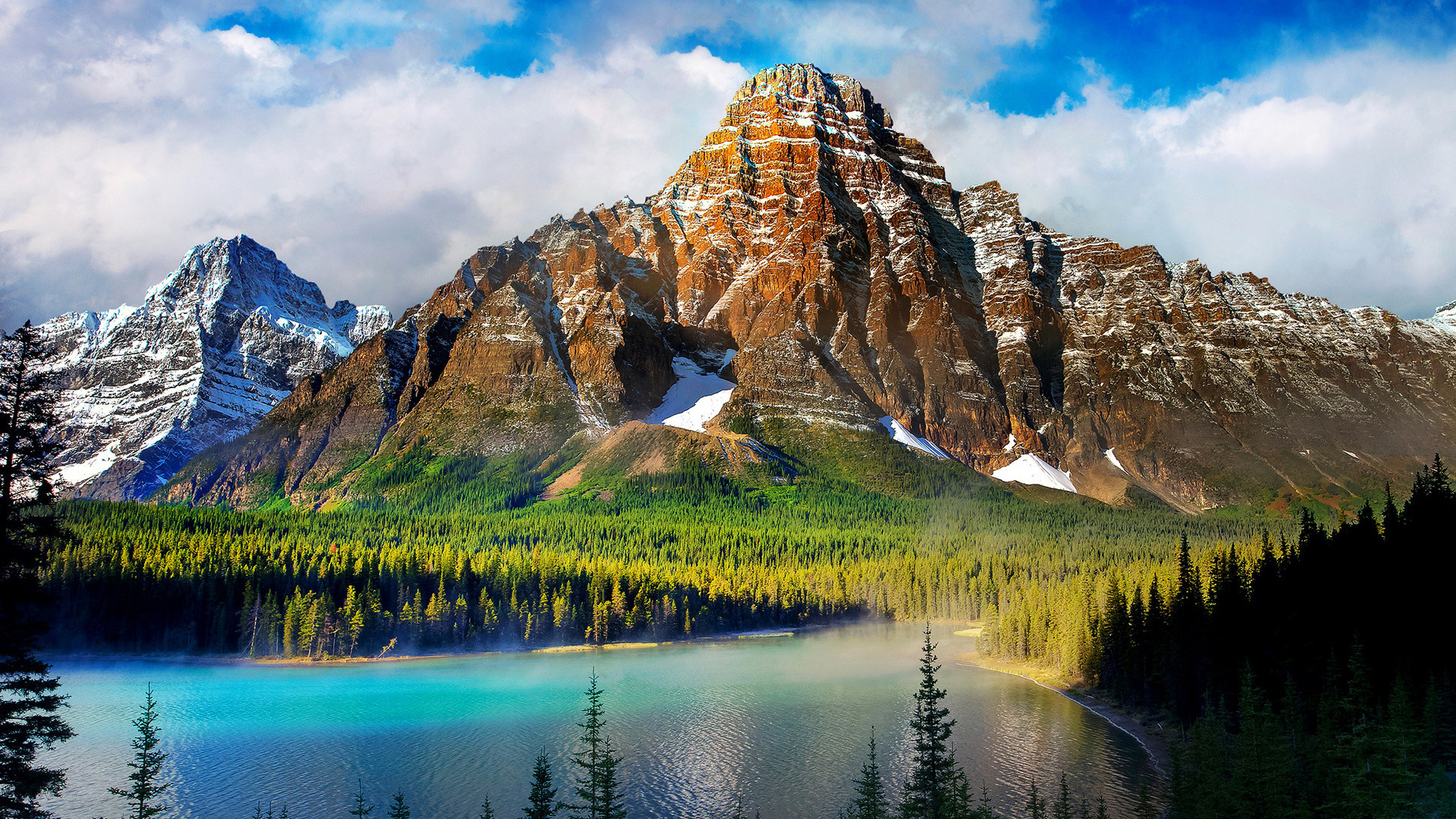 A stunning landscape of a turquoise lake nestled beneath towering, snow-capped mountains, surrounded by a vibrant evergreen forest, evoking the tranquility of nature