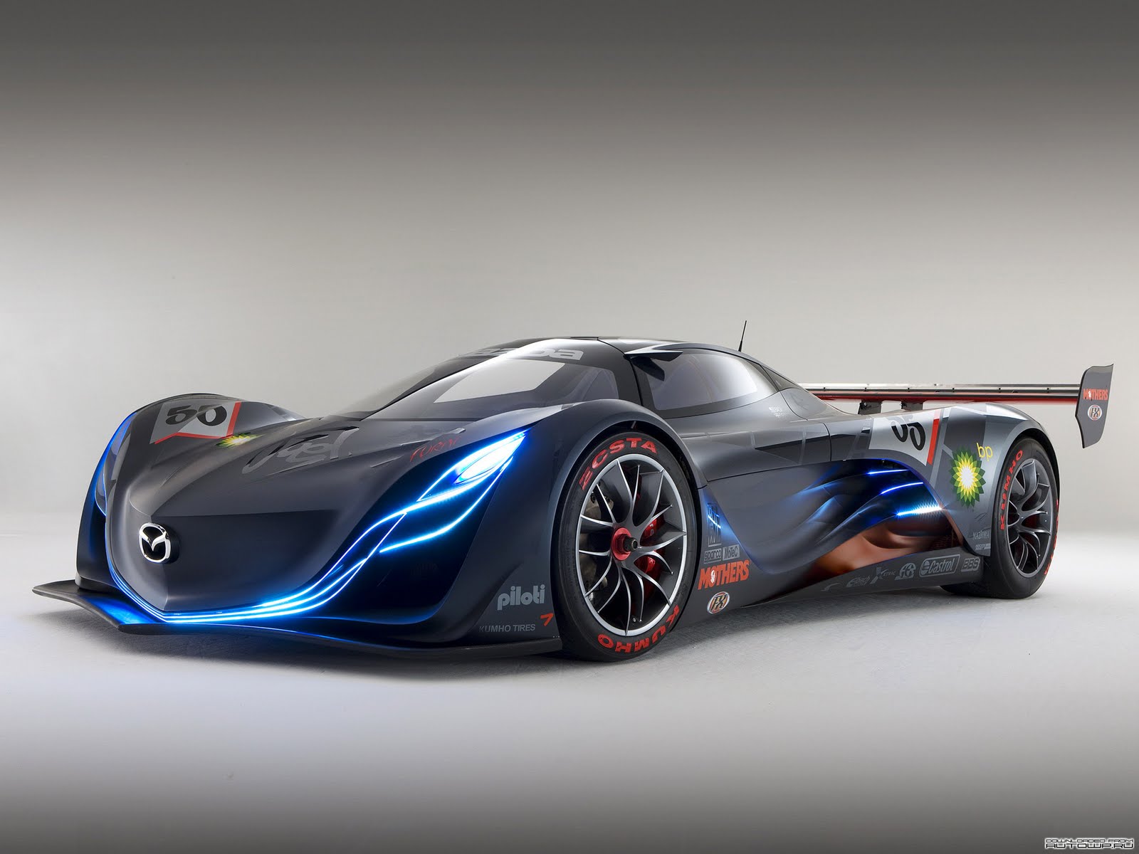 Futuristic Mazda concept car with glowing blue lights, sleek design, and racing sponsors
