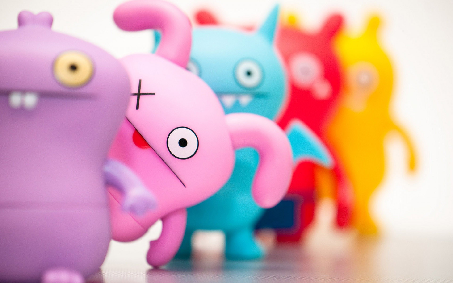 Colorful and cute Uglydolls toys lined up against a white background