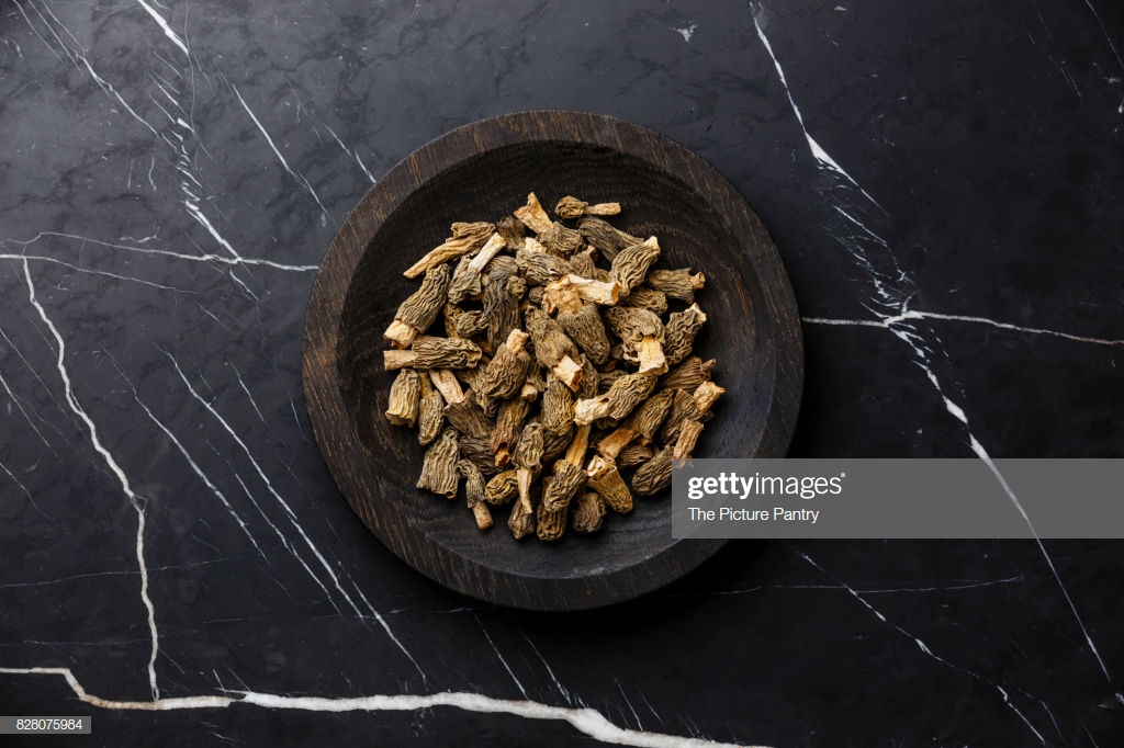 Dried Morel Mushroom On Wooden Plate Dark Marble Background